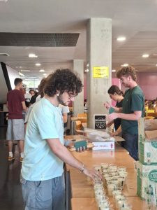 Students serve cups of horchata and fartons at a long table on the ground floor of the Student Recreation Centre while others queue