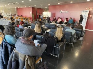 Audience in armchairs listening to a panel of speakers at the Art and Heritage Collection's Caferencia at the Student Recreation Centre