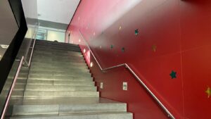 Student Recreation Centre staircase with its red wall decorated with green and gold stars for Christmas