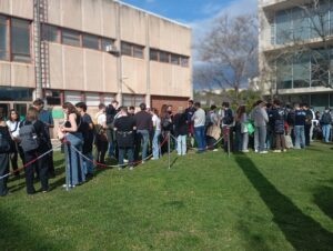 Nombrosos estudiants fan cua darrere d'unes cintes sobre la gespa dels jardins de la Casa de l'Estudiant durant el Welcome Day
