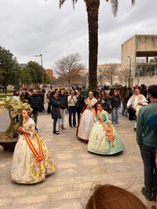Falleras con el traje tradicional valenciano y la banda al pecho recorren el campus entre el público durante la jornada fallera de la Mascletà 2026