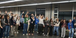 Participants del VII Congrés CREUP-CRUE amb acreditacions alcen la mà durant una activitat a la Casa de l'Estudiant