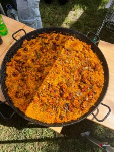 A large paella with meat and green beans on a table on the grass during Welcome Day