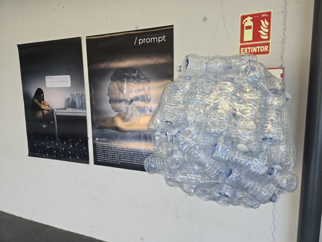 Dues fotografies de gran format, una titulada «/ prompt», i una escultura penjada feta amb ampolles d'aigua de plàstic buides