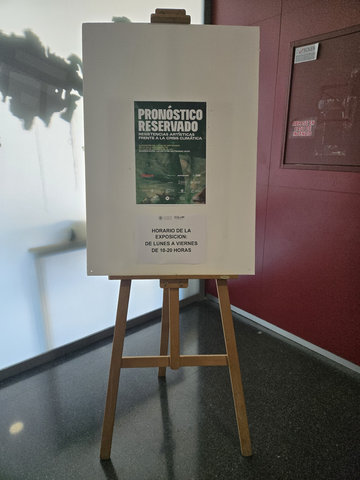 Cavallet amb el cartell de «Pronóstico Reservado» i un avís de l'horari de l'exposició: de dilluns a divendres, de 10:00 a 20:00