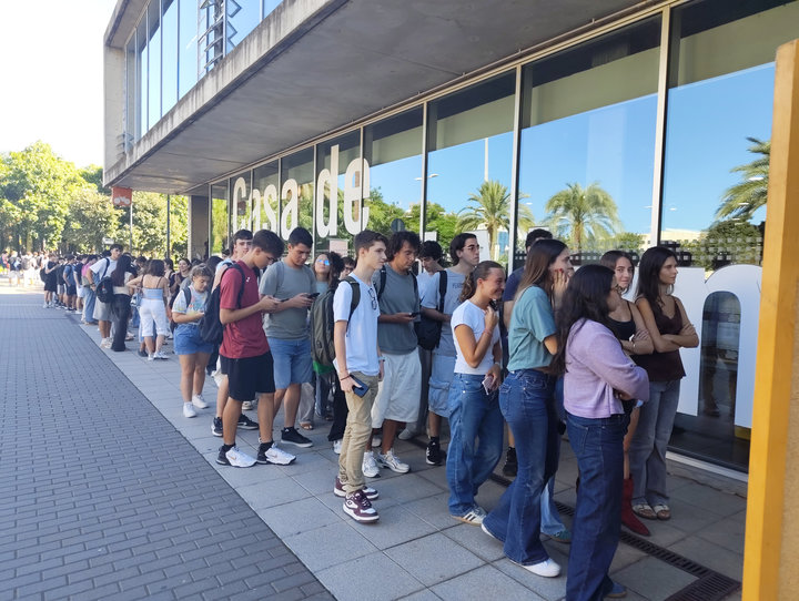 Llarga cua d'estudiants a l'exterior, al llarg de la façana de vidre de la Casa de l'Estudiant, esperant l'orxatada